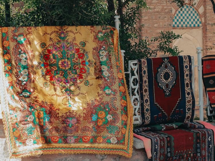 Four colorful oriental rugs hanging outdoors to dry from floodwater